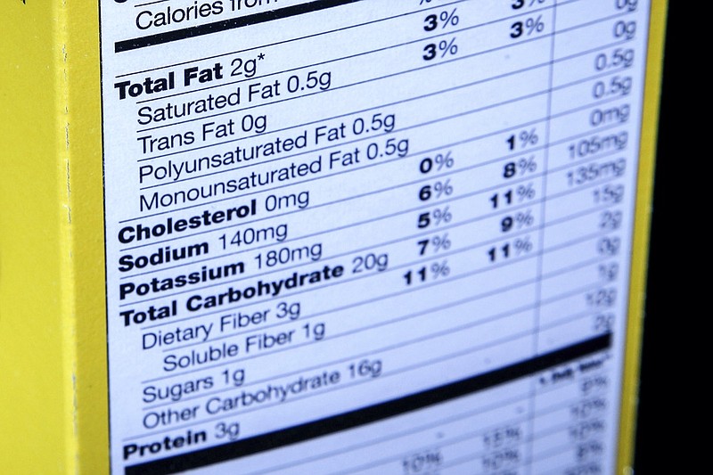 FILE - This Jan. 23, 2014 file photo shows the nutrition facts label on the side of a cereal box in Washington. Food companies are coming under renewed pressure to use less salt after U.S. regulators spelled out target sodium levels for dozens of foods including condiments, french fries and potato chips.(AP Photo/J. David Ake, File)
