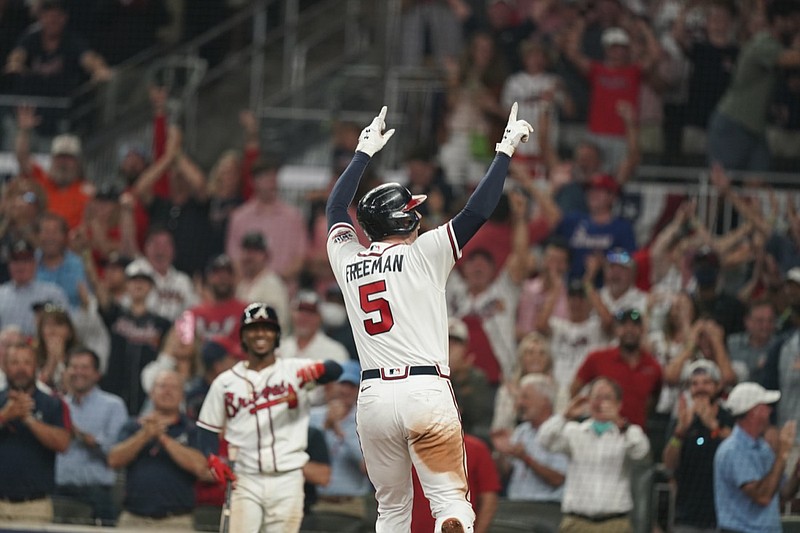 Atlanta Braves Freddie Freeman celebrates his solo homer against the Milwaukee Brewers during the eighth inning of Game 4 of a baseball National League Division Series, Tuesday, Oct. 12, 2021, in Atlanta. The Atlanta Braves won 5-4 to advance to the NLCS. (AP Photo/Brynn Anderson)