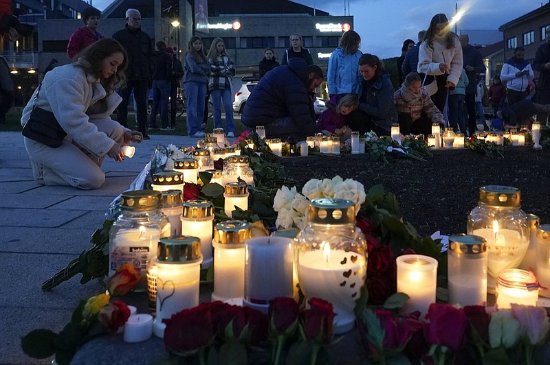 Flowers and candles are placed at the scene of an attack on the square, in Kongsberg, Norway, Thursday, Oct. 14, 2021. Norwegian authorities say the bow-and-arrow rampage by a man who killed five people in a small town appeared to be a terrorist act. (Terje Bendiksby/NTB via AP)

