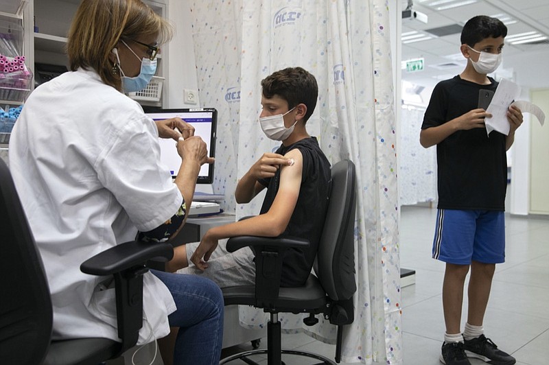 FILE - In this June 6, 2021 file photo, a youth receives a Pfizer-BioNTech COVID-19 vaccine in the central Israeli city of Rishon LeZion. (AP Photo/Sebastian Scheiner)


