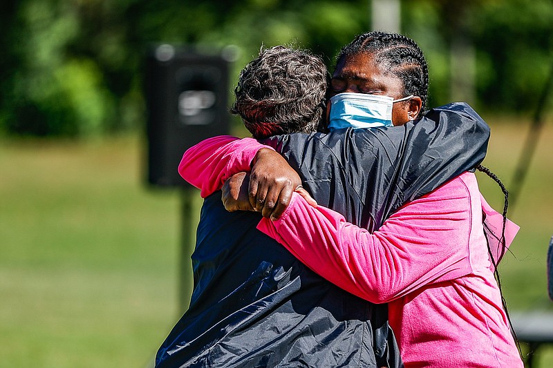 Staff photo by Troy Stolt / Westside resident Cassandra Robertson hugs Betty Maddox after speaking at a rally to seek justice for the women shot on Grove Street last month on Saturday, Oct. 16, 2021 in Chattanooga, Tenn.