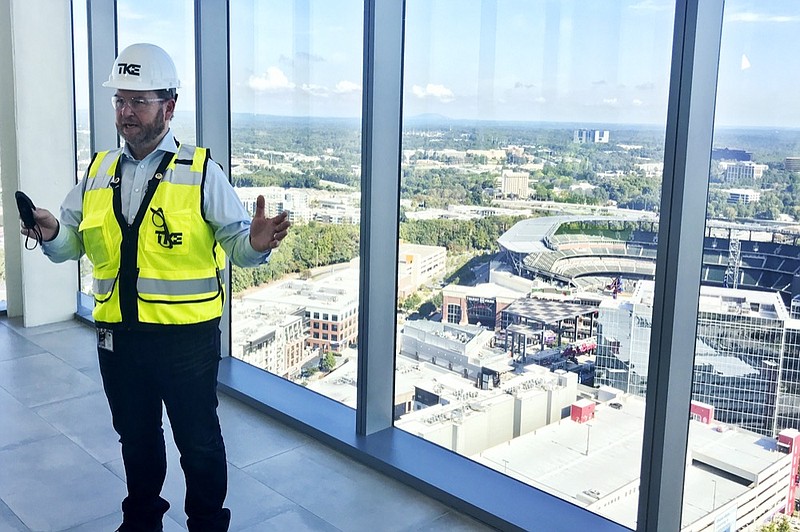 Kevin Lavallee, CEO of TK Elevators' North American operations, stands at the top of the company's new elevator testing facility, Wednesday, Oct. 13, 2021, that towers over the Atlanta Braves stadium and surrounding skyscrapers northwest of Atlanta. (AP Photo/Jeff Martin)


