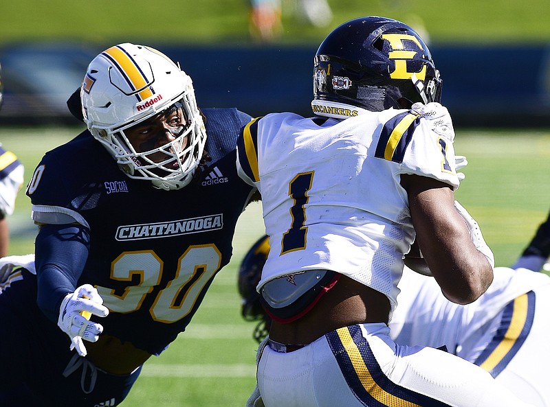 Staff photo by Robin Rudd / UTC's Jay Person (30) tackles East Tennessee's Quay Holmes during Saturday's SoCon football game at Finley Stadium. Person recovered two fumbles that set up UTC touchdown drives as the Mocs won 21-16.