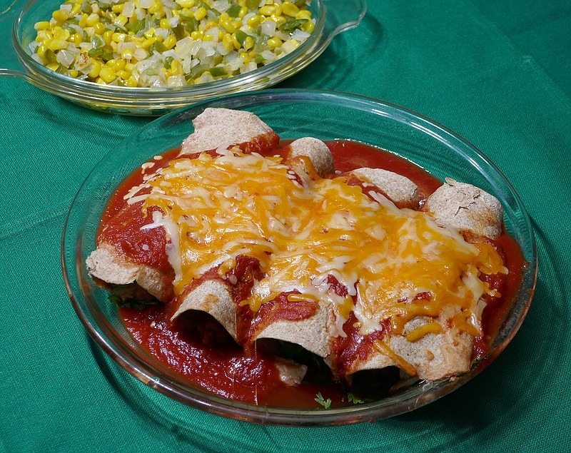 Chicken enchiladas are served with esquites (sauteed corn). / Photo by Linda Gassenheimer/TNS