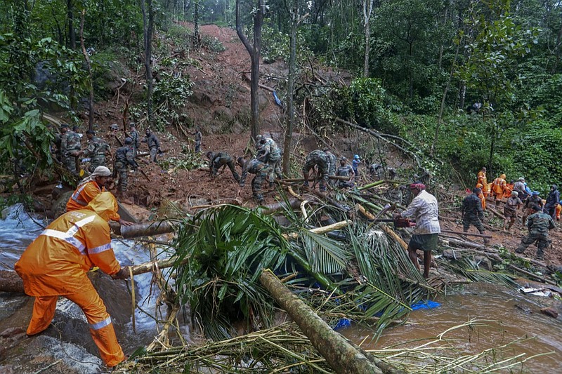 Rescuers search for bodies of victims amist the debris of a landslide following heavy rains at Koottickal in Kottayam district, southern Kerala state, India, Sunday, Oct.17, 2021. More than two dozen people have died in the state due to intense rains which have triggered floods and landslides. (AP Photo)
