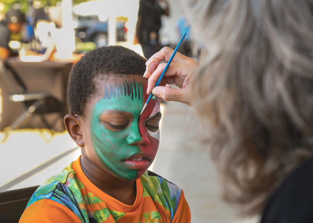 Photography by Mark Gilliland / Tazarrius Hughley gets face painted by Susanne Bowling