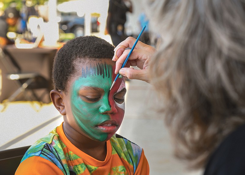 Photography by Mark Gilliland / Tazarrius Hughley gets face painted by Susanne Bowling