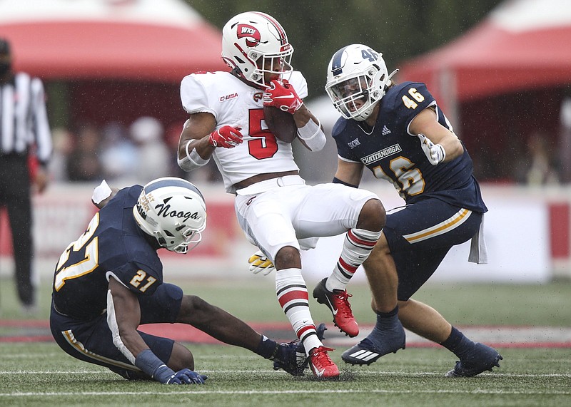 Staff photo by Troy Stolt / Chattanooga Mocs defensive back Jerrell Lawson (27) and Chattanooga Mocs linebacker Ty Boeck (46) tackle Western Kentucky Hilltoppers running back Gaej Walker (5) during the first half of the Chattanooga Mocs football game against the Western Kentucky Hilltoppers at Houchens Industries-L.T. Smith Stadium on Saturday, Oct. 24, 2020 in Bowling Green , Kentucky.