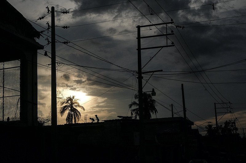 Youths run on a rooftop in the Delmas neighborhood during the general strike in Port-au-Prince, Monday, Oct. 18, 2021. Workers angry about the nation's lack of security went on strike in protest two days after 17 members of a US-based missionary group were abducted by a violent gang. (AP Photo/Matias Delacroix)