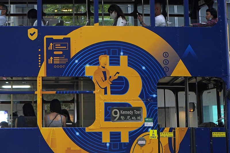 FILE - This May 12, 2021, file photo shows an advertisement for the cryptocurrency Bitcoin displayed on a tram in Hong Kong. Cryptocurrencies have surged to nearly $2.5 trillion in total value, rivaling the size of G7 economies like Canada's and Italy's, with more than 200 million users. At that size, it's simply too large for the financial establishment to ignore. Firms that cater to the world's wealthiest families are increasingly putting some of their fortunes into crypto. Hedge funds are trading Bitcoin, which has big-name banks starting to offer them services around it. And in the latest milestone for the industry, an easy-to-trade fund tied to Bitcoin began trading on Tuesday, Oct. 19, 2021. (AP Photo/Kin Cheung, File)