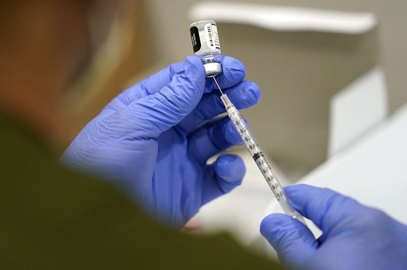 FILE - In this Oct. 5, 2021, file photo a healthcare worker fills a syringe with the Pfizer COVID-19 vaccine at Jackson Memorial Hospital in Miami. (AP Photo/Lynne Sladky, File)


