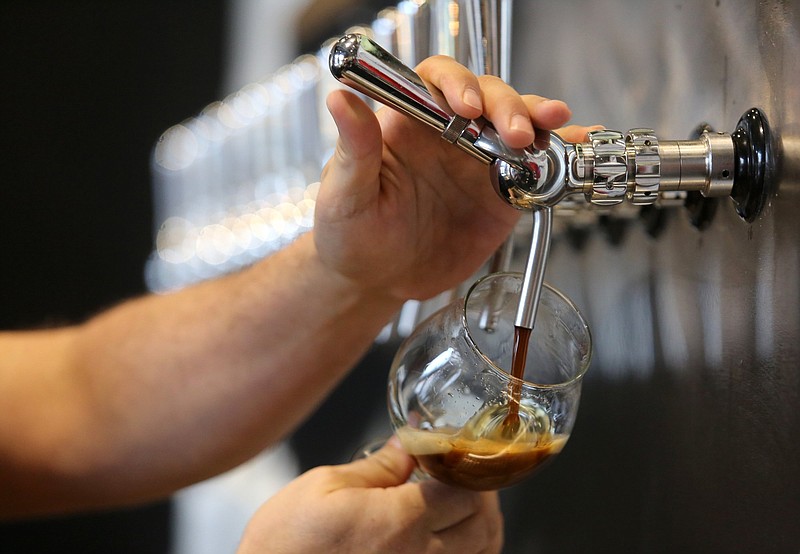 Staff file photo by Erin O. Smith / Joe Winland, owner of Heaven and Ale Brewery, pours a glass of at Heaven and Ale Brewery in Chattanooga in a 2019 file photo. Red Bank hopes to attract more businesses by easing restrictions on businesses that serve beer.