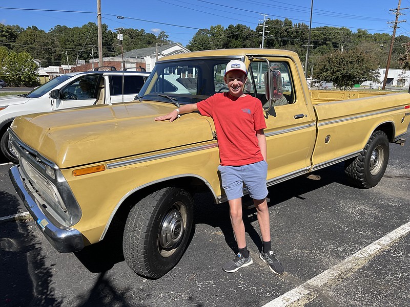 Staff photo by Mark Kennedy / Brooks Kennedy, 14, poses by a 1973 Ford pickup purchased by his family at the Mecum Auction in Chattanooga on Oct. 16, 2021.