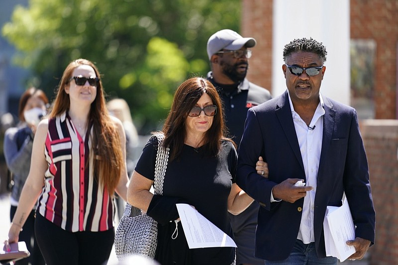 AP photo by Matt Rourke / Former NFL players Ken Jenkins, right, and Clarence Vaughn III, center right, along with their wives, Amy Lewis, center, and Brooke Vaughn, left, carry petitions demanding equal treatment for everyone involved in the settlement of concussion claims against the NFL, to the federal courthouse in Philadelphia on May 14, 2021.