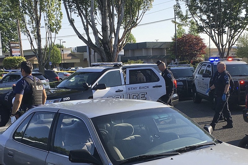 In this May 31, 2019, photo provided by the Auburn Police Department via the Port of Seattle Police Department, Auburn police Officer Jeff Nelson, second from right, is shown at the scene where he shot and killed Jesse Sarey in a grocery store parking lot in Auburn, Wash. (Auburn Police Department via Port of Seattle Police Department via AP)


