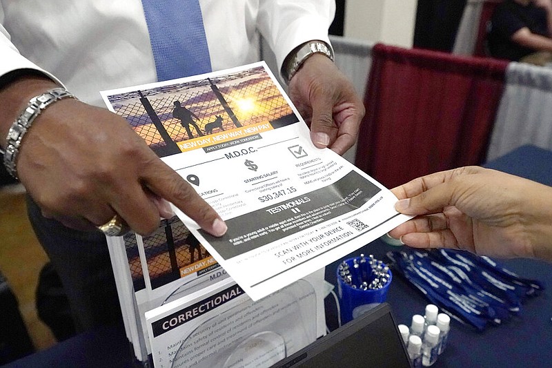 Curtis McCray, a Mississippi Department of Corrections recruiter, left, points out a positive testimonial to a job applicant during the Lee County Area Job Fair in Tupelo, Miss., Tuesday, Oct. 12, 2021. Employers representing a variety of manufacturing, production, service industry, medical and clerical companies attended the day long affair with an eye towards recruitment, hiring, training and retention. (AP Photo/Rogelio V. Solis)