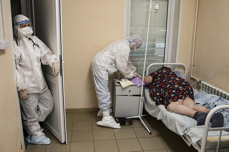A medical staff member in a protective suit treats a COVID-19 patient at an ICU in Infectious Hospital No. 2 in Nizhny Novgorod, Russia, on Wednesday, Oct. 20, 2021. (AP Photo/Roman Yarovitcyn)