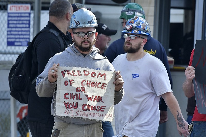 Justin Paetow, who works in the tin shop at Bath Iron Works, demonstrates against COVID-19 vaccine mandate outside the shipyard on Friday, Oct. 22, 2021, in Bath, Maine. (AP Photo/Josh Reynolds)


