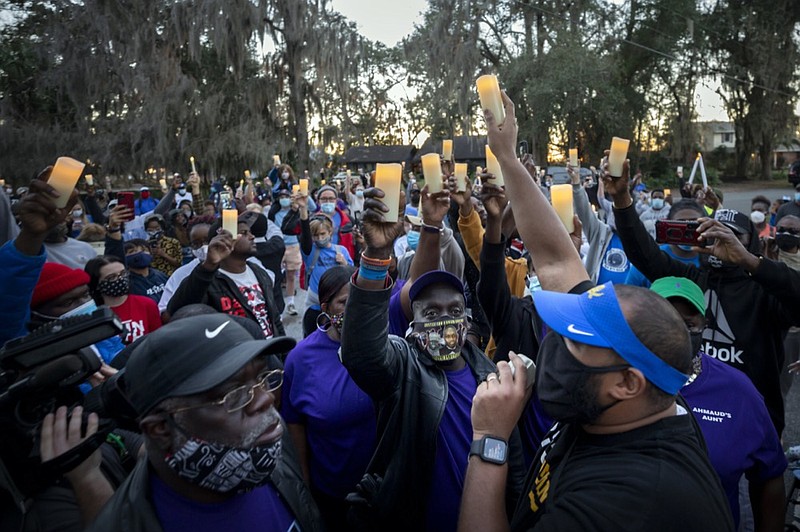 FILE - In this Tuesday, Feb. 23, 2021, file photo, Ahmaud Arbery's father, Marcus Arbery, bottom center, listens to Jason Vaughn speak during a memorial walk and candlelight vigil for Ahmaud at the Satilla Shores development, in Brunswick, Ga. (AP Photo/Stephen B. Morton, File)


