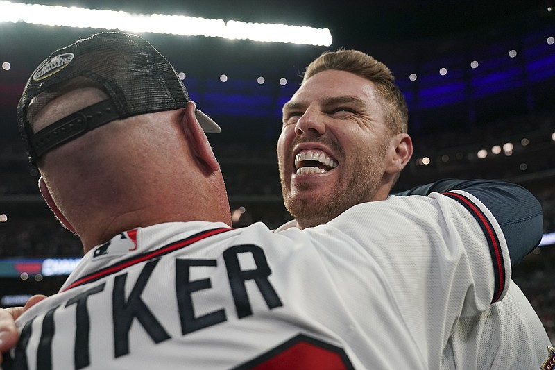 AP photo by Brynn Anderson / Atlanta Braves manager Brian Snitker hugs first baseman Freddie Freeman after the team's 4-2 victory against the visiting Los Angeles Dodgers on Saturday night to win the NLCS in six games.