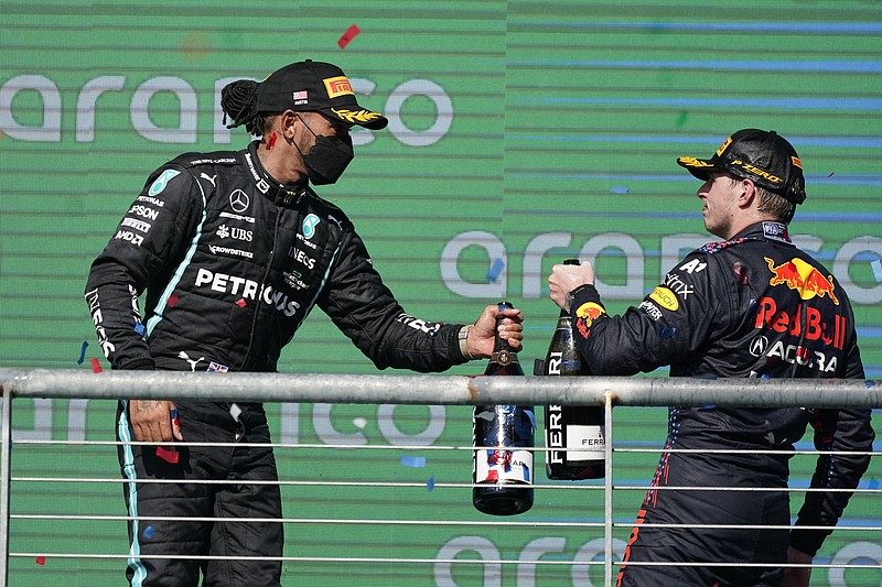 AP photo by Darron Cummings / Red Bull driver Max Verstappen, right, and Mercedes driver Lewis Hamilton bump bottles after Sunday's U.S. Grand Prix at the Circuit of the Americas in Austin, Texas. Verstappen won and Hamilton was second, allowing the Red Bull driver to double his lead over Hamilton in the Formula One season championship standings.