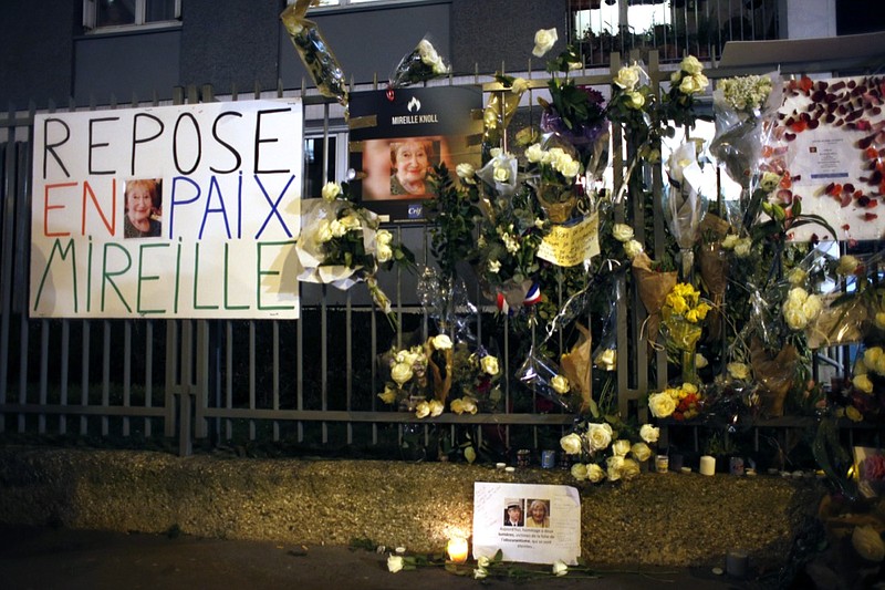 FILE - In this Wednesday, March 28, 2018 file photo, flowers and placards are displayed outside Mireille Knoll's apartment during a silent march in Paris, France. Two men went on trial in Paris on Tuesday, Oct. 26 2021 accused of killing an 85-year-old French Holocaust survivor. Mireille Knoll was stabbed to death in 2018 in her Paris apartment in what prosecutors call an anti-Semitic attack. (AP Photo/Thibault Camus, file)