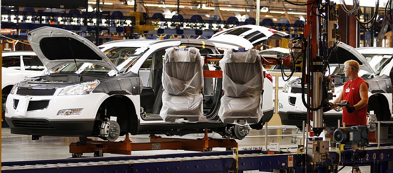 FILE - In this Oct. 3, 2008 file photo, assembly line worker Melvin Matthews, right, uses a large robotic machine to install front seats in a Chevrolet Traverse at the GM Spring Hill Manufacturing Plant, in Spring Hill, Tenn. The French automotive suppplier Faurecia is planning to more than double its operations in Spring Hill. (AP Photo/Bill Waugh, File)