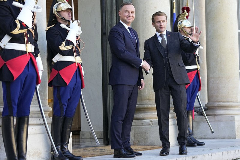 French President Emmanuel Macron, right, and Poland's President Andrzej Duda shake hands before a working lunch at the Elysee Palace Wednesday, Oct. 27, 2021 in Paris. The European Union's top court has ordered Poland to pay 1 million euros a day ($1.2 billion) over the country's longstanding dispute with the bloc over judicial independence. (AP Photo/Michel Euler)