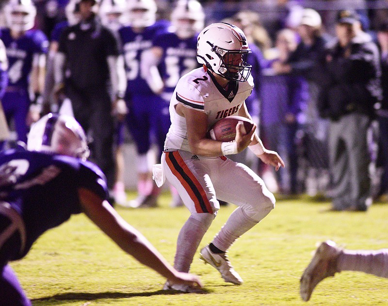 Staff photo by Robin Rudd / Meigs County quarterback Logan Carroll looks for running room during Friday night's 20-0 win at Marion County, where the Tigers wrapped up the Region 3-2A championship and a No. 1 seed for the state playoffs. The Chattanooga area has 26 teams in the TSSAA football postseason.