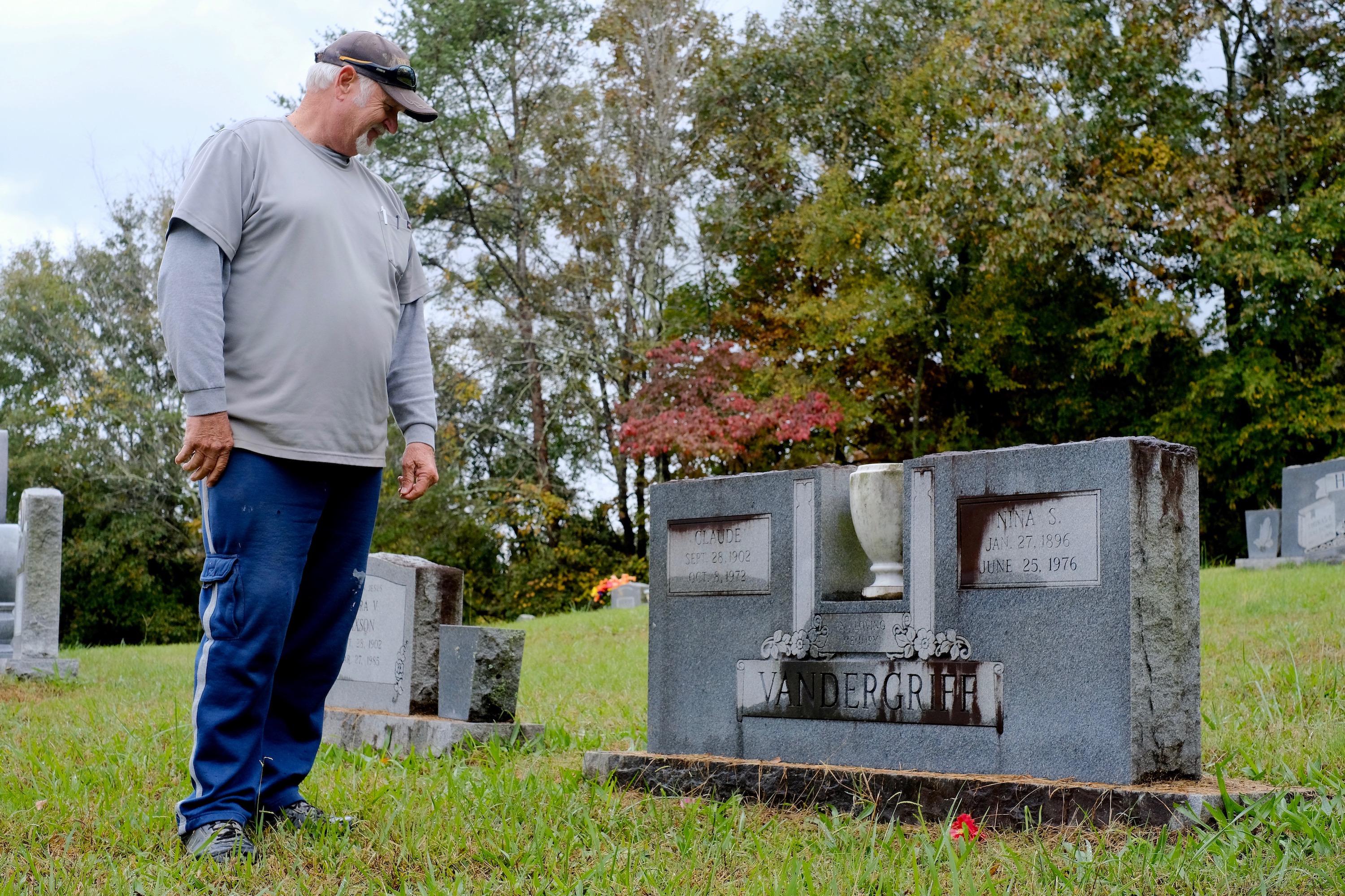 Staff photo by Wyatt Massey / Dennis Harvey stands beside his grandparents' tombstone in the Friendship Baptist Church cemetery in Hixson on Oct. 29, 2021. Harvey's grandparents donated the land to create the cemetery in 1957.