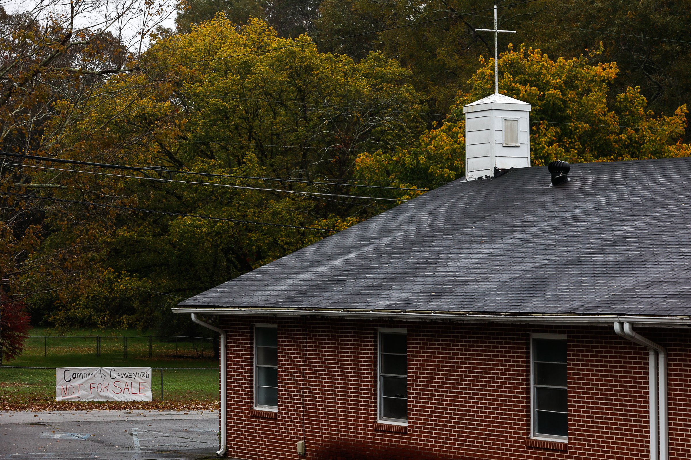 Staff photo by Troy Stolt / A sign that reads "Community Cemetery is not for sale" hangs on a fence on a property across the street from Friendship Baptist Church on Thursday, Oct. 28, 2021, in Chattanooga, Tenn. The church, which has relocated to another location off of Gadd Road, announced its intention to sell the former location and the cemetery located behind the building.