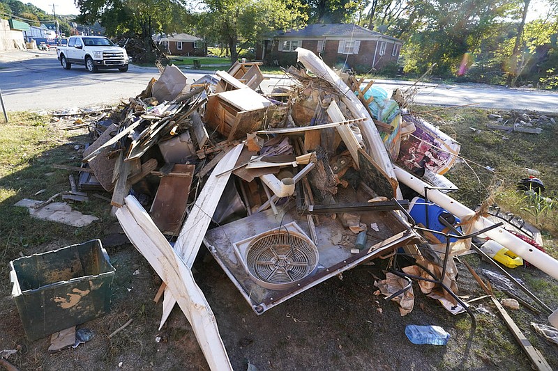 A truck passes a pile of debris Sept. 27, 2021, in Waverly, Tenn. / AP Photo/Mark Humphrey