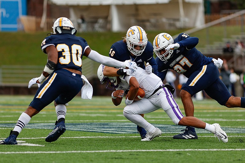 Staff photo by Troy Stolt / UTC linebacker Ty Boeck (46) tackles Furman running back Kendall Thomas during Saturday's SoCon game at Finley Stadium.