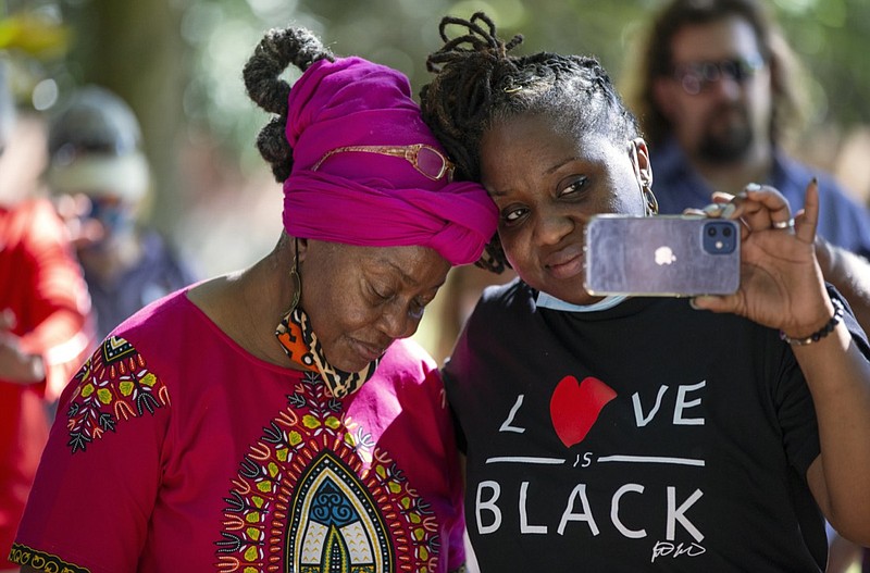 Mamie Hillman, left, leans on her daughter Lea Smith during an honoring of the ancestors ceremony, where friends and family of those buried at the Penfield African American Cemetery gathered to pay their respects, in Greene County, Ga., Saturday, Oct. 16, 2021. For Hillman, it was the first step in encapsulating the long-overlooked history of Black leaders in Greene County. (Kayla Renie/Athens Banner-Herald via AP)

