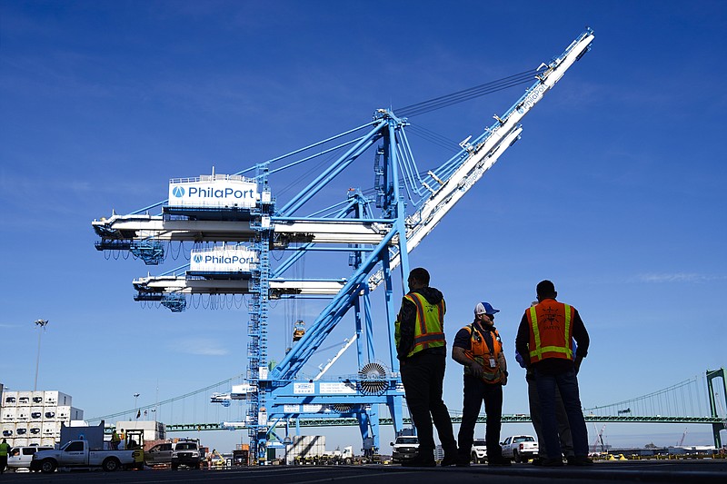 Photo by Matt Rourke of The Associated Press / Workers stand by cranes at the Port of Philadelphia on Thursday, Oct. 28, 2021.