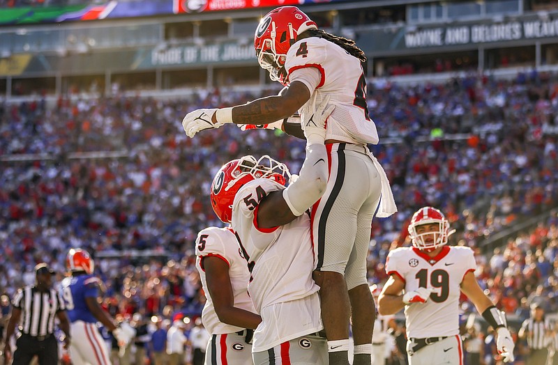 Georgia photo by Mackenzie Miles / Georgia left guard Justin Shaffer lifts up running back James Cook following a Cook touchdown during last Saturday's 34-7 win over Florida in Jacksonville.