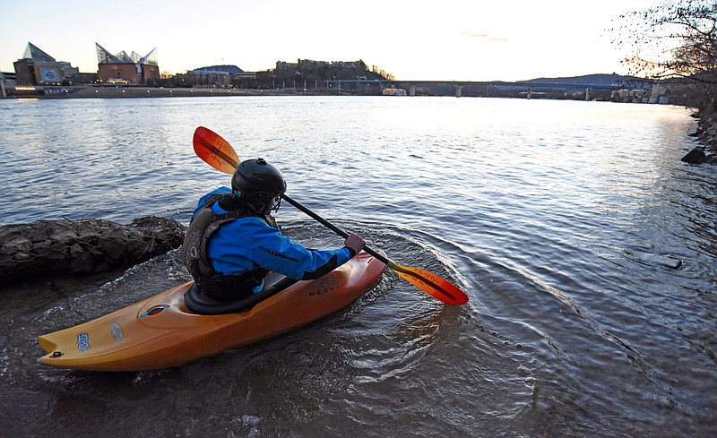Staff Photo by Matt Hamilton / Chattanooga resident Tom Sweets takes his kayak out in the Tennessee River at the landing at Coolidge Park at sunset on Monday, Jan. 18, 2021. 