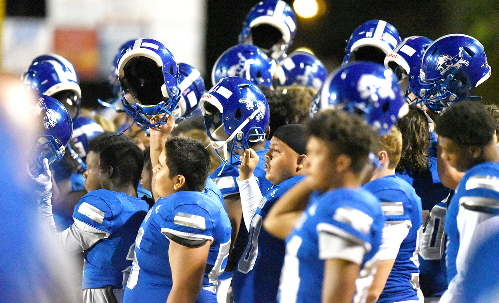 Staff file photo by Matt Hamilton / Red Bank football players hold up their helmets before a home game kicks off. The Lions (7-3) will host Stone Memorial (6-4) for the first round of the Class 4A playoffs on Friday.