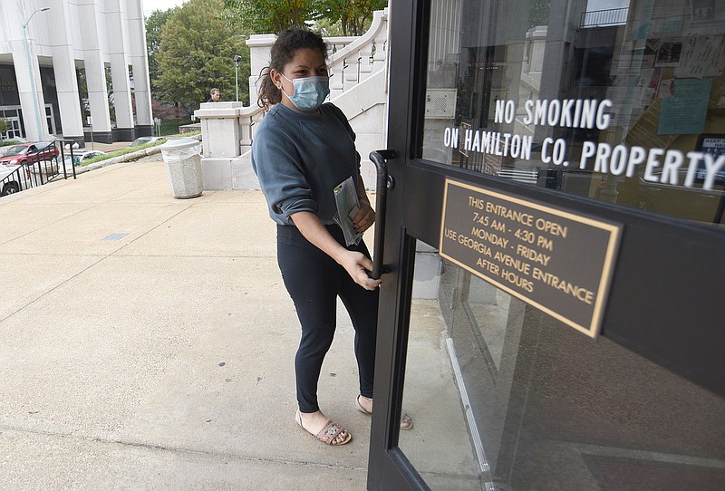 Staff Photo by Matt Hamilton / Brenda Garcia dons a mask as she renews her tag at the Hamilton County Courthouse on Friday, November 5, 2021.