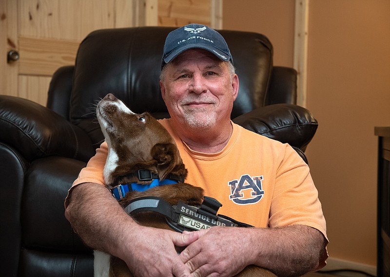 (Photo by Mark Gilliland) United States Air Force Veteran Michael Giovo at his home in Trenton, Georgia on October 25, 2021. Giovo sits with his service dog Casey. Giovo was diagnosed PTSD.