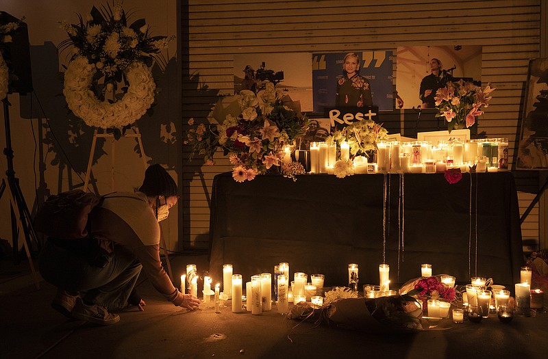 A mourner places a candle during a vigil on Oct. 24, 2021, at IATSE Local 80 in Burbank, California, for cinematographer Halyna Hutchins, who was fatally shot accidentally by Alec Baldwin on the "Rust" movie set at Bonanza Creek Ranch outside Santa Fe, New Mexico, on Oct. 21, 2021. (Myung J. Chun/Los Angeles Times/TNS)