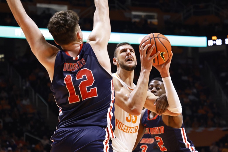 Tennessee forward Uros Plavsic (33) goes for a shot as he's fouled by Tennessee-Martin guard KJ Simon (2) and David Didenko (12) during an NCAA college basketball game Tuesday, Nov. 9, 2021, in Knoxville, Tenn. Tennessee won 90-62. (AP Photo/Wade Payne)