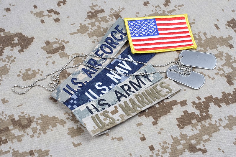Getty Images / Branch tapes and dog tags are seen on a camouflage uniform background.