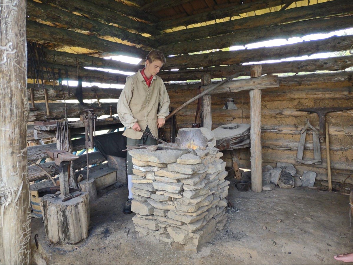 Contributed Photo by Patti Smith / Noah Smith, a re-enactor at Virginia's Wilderness Road State Park, works the bellows to forge red hot iron into useful implements.