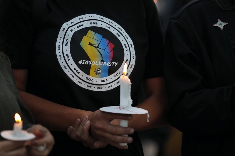 FILE - Movie industry worker Hailey Josselyn, wearing a t-shirt of the International Alliance of Theatrical Stage Employees (IATSA), holds a candle during a vigil to honor cinematographer Halyna Hutchins in Albuquerque, N.M., on Oct. 23, 2021. Hutchins was fatally shot on Thursday, Oct. 21, after an assistant director unwittingly handed actor Alec Baldwin a loaded weapon and told him it was safe to use on the set of a Western filmed in Santa Fe, N.M. (AP Photo/Andres Leighton, File)



