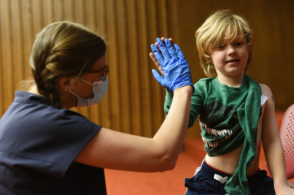 Staff Photo by Matt Hamilton / Nurse practitioner Meghan Whitehead exchanges a high five with Lookout Mountain resident Kizer Burbank, 7, after giving him a COVID-19 vaccination shot on Friday, November 13, 2021 at the downtown branch of the Chattanooga Public Library. Lifespring Community Health was providing vaccination shots to children as young as five years old on Friday.