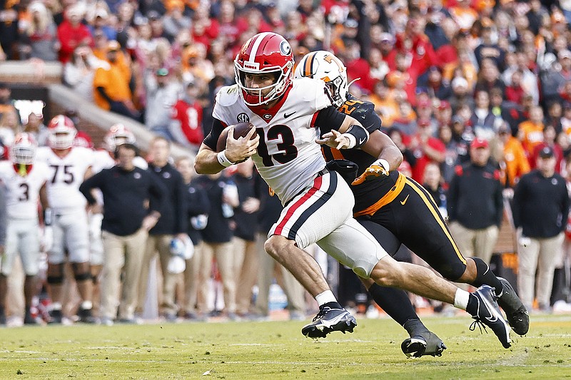 AP photo by Wade Payne / Georgia quarterback Stetson Bennett runs for a touchdown as he's chased by Tennessee linebacker Aaron Beasley during the first half Saturday in Knoxville.