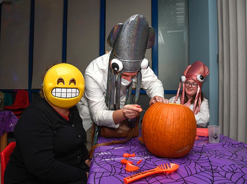 Photo by Mark Gilliland / Beth, Chris and Erin Miller carve a pumpkin.