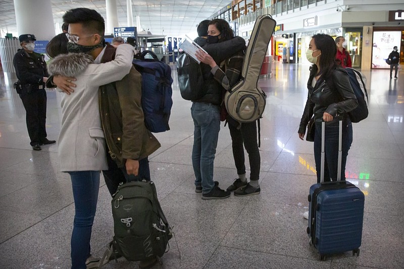 FILE - Wall Street Journal reporters, from right, Stephanie Yang, Julie Wernau, and Stu Woo embrace colleagues before their departure at Beijing Capital International Airport in Beijing on March 28, 2020.  (AP Photo/Mark Schiefelbein, File)


