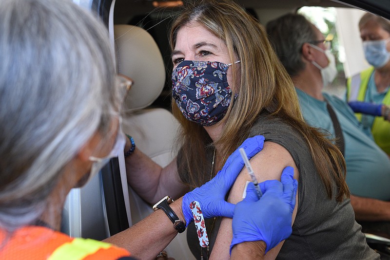 Staff Photo by Matt Hamilton / Nurse Abbe Hildebrandt, left, administers a dose of vaccine to Chattanooga resident Holli Harris as nurse Sandra Young, back right, administers a dose to her husband Allen Harris at the Tennessee Riverpark in September.
